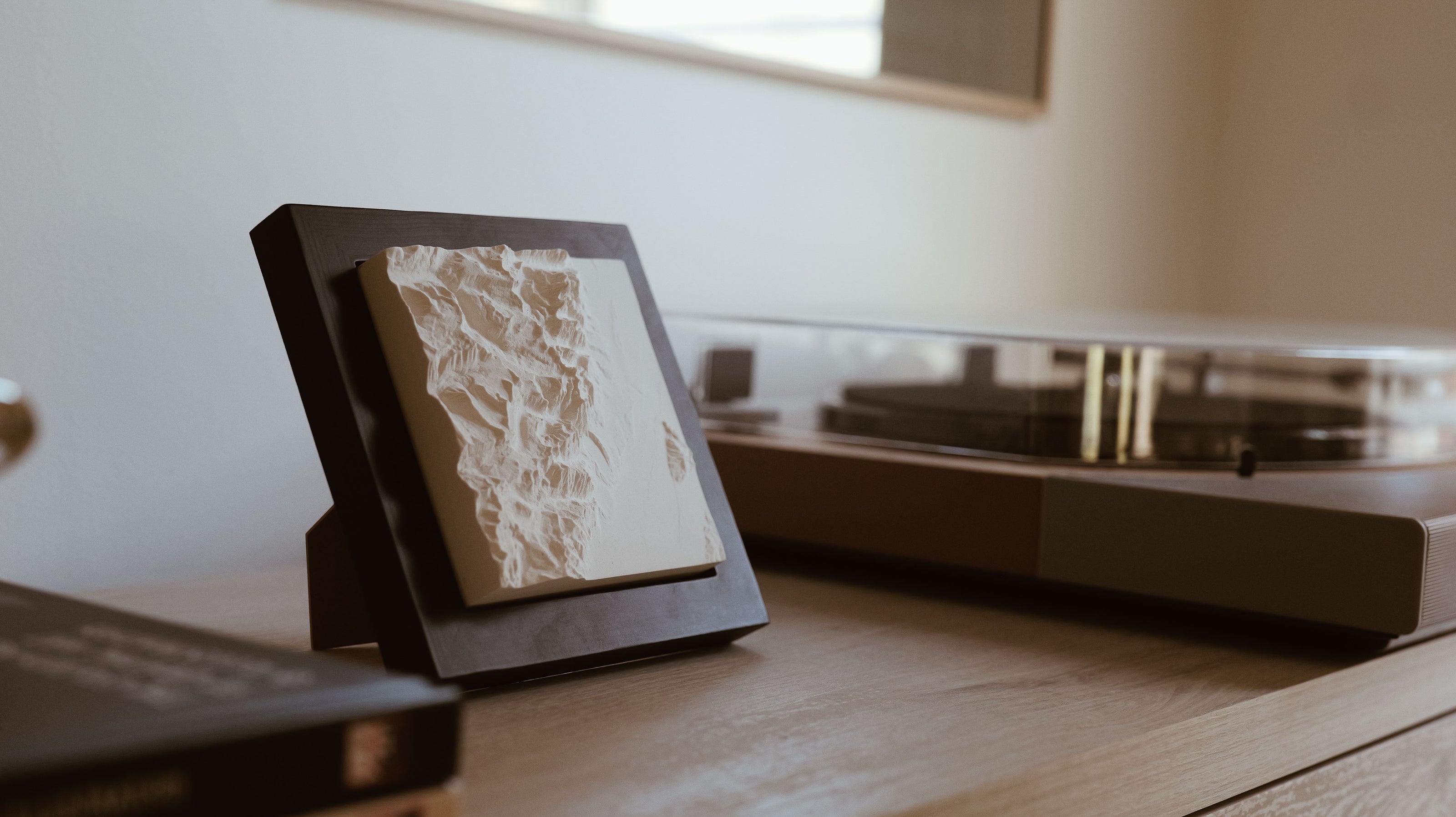 Mountain model sitting on a shelf with a record player behind it. 