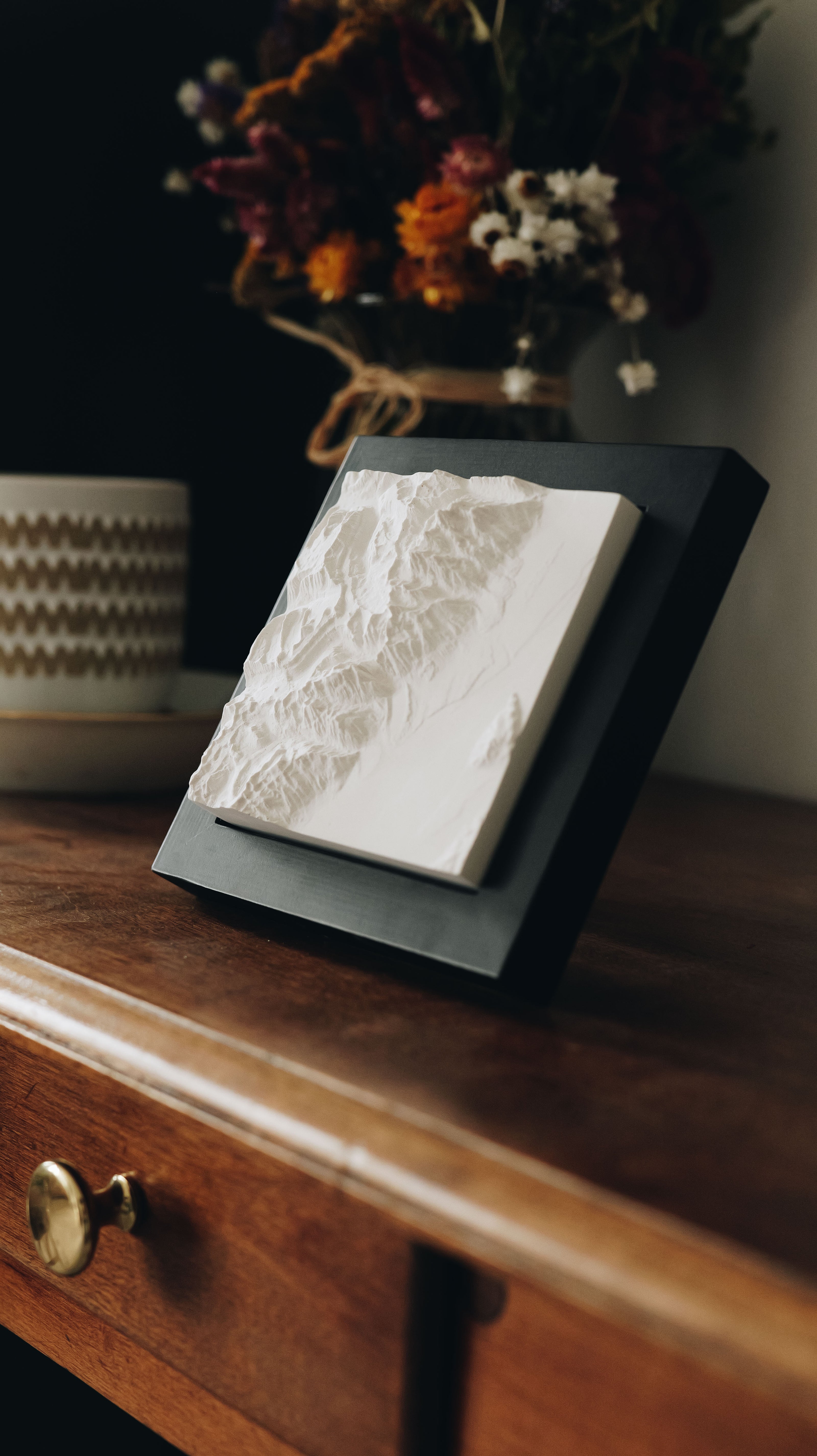 A mountain model sitting on a counter. 