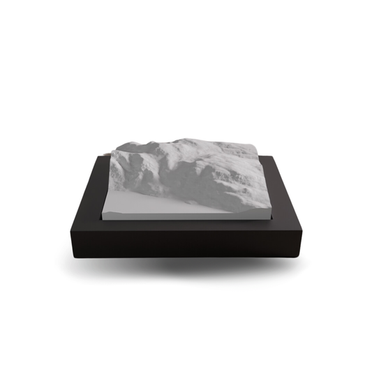 Model of a mountain on a black base with a white background