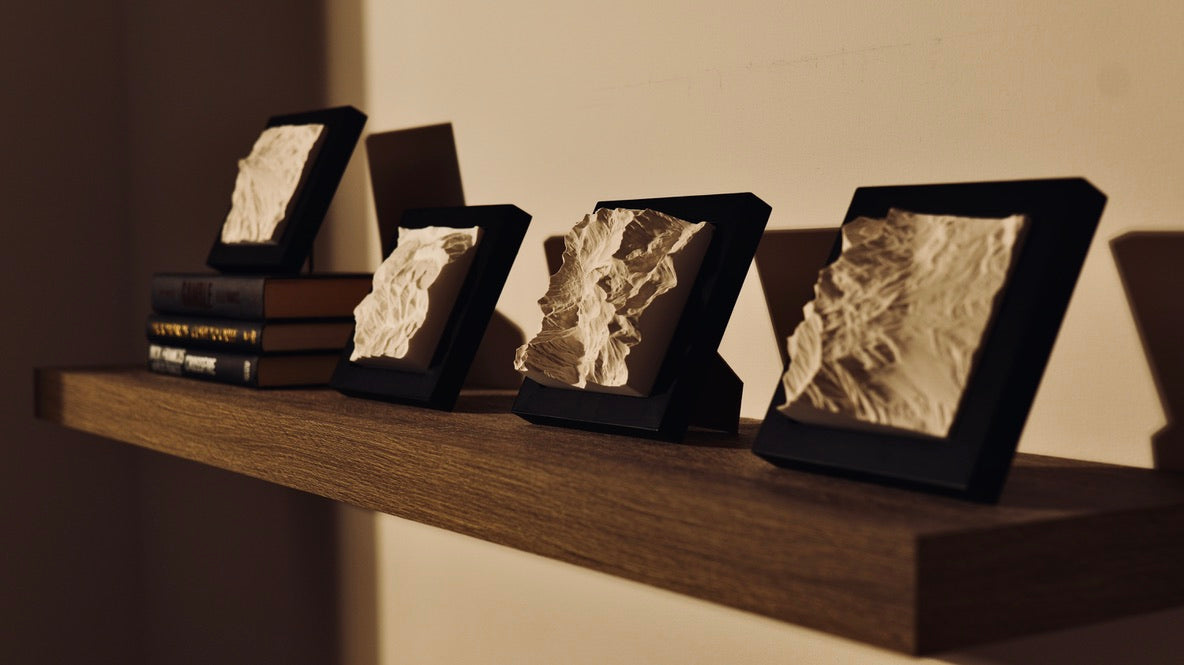 Mountain models on a shelf with decorations.