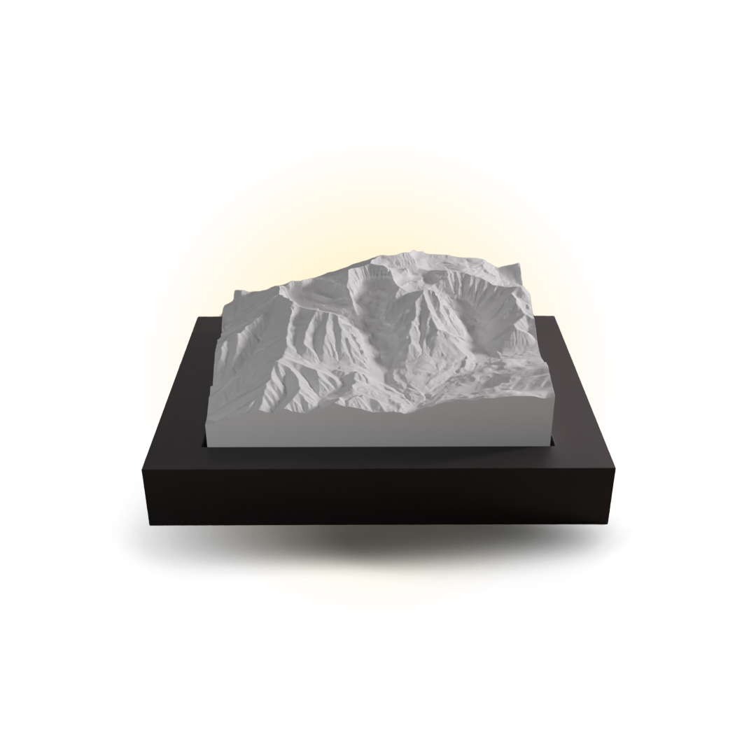 Mountainous landscape model on a black base with a white light behind