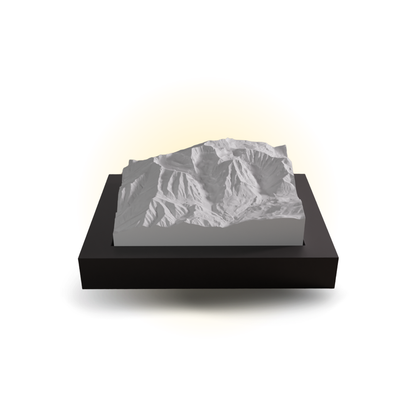 Mountainous landscape model on a black base with a white light behind