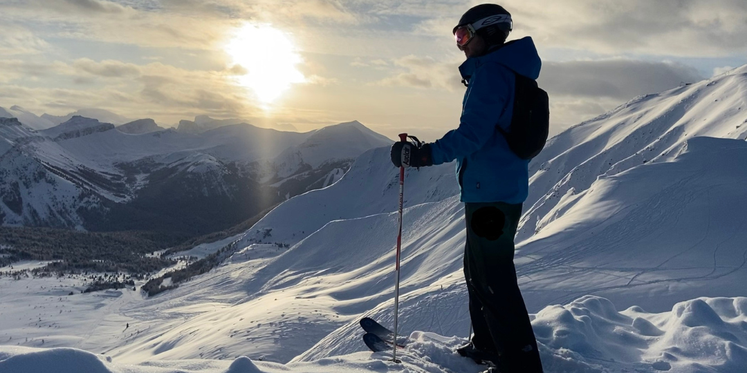 Teagan standing on a mountain with skis.